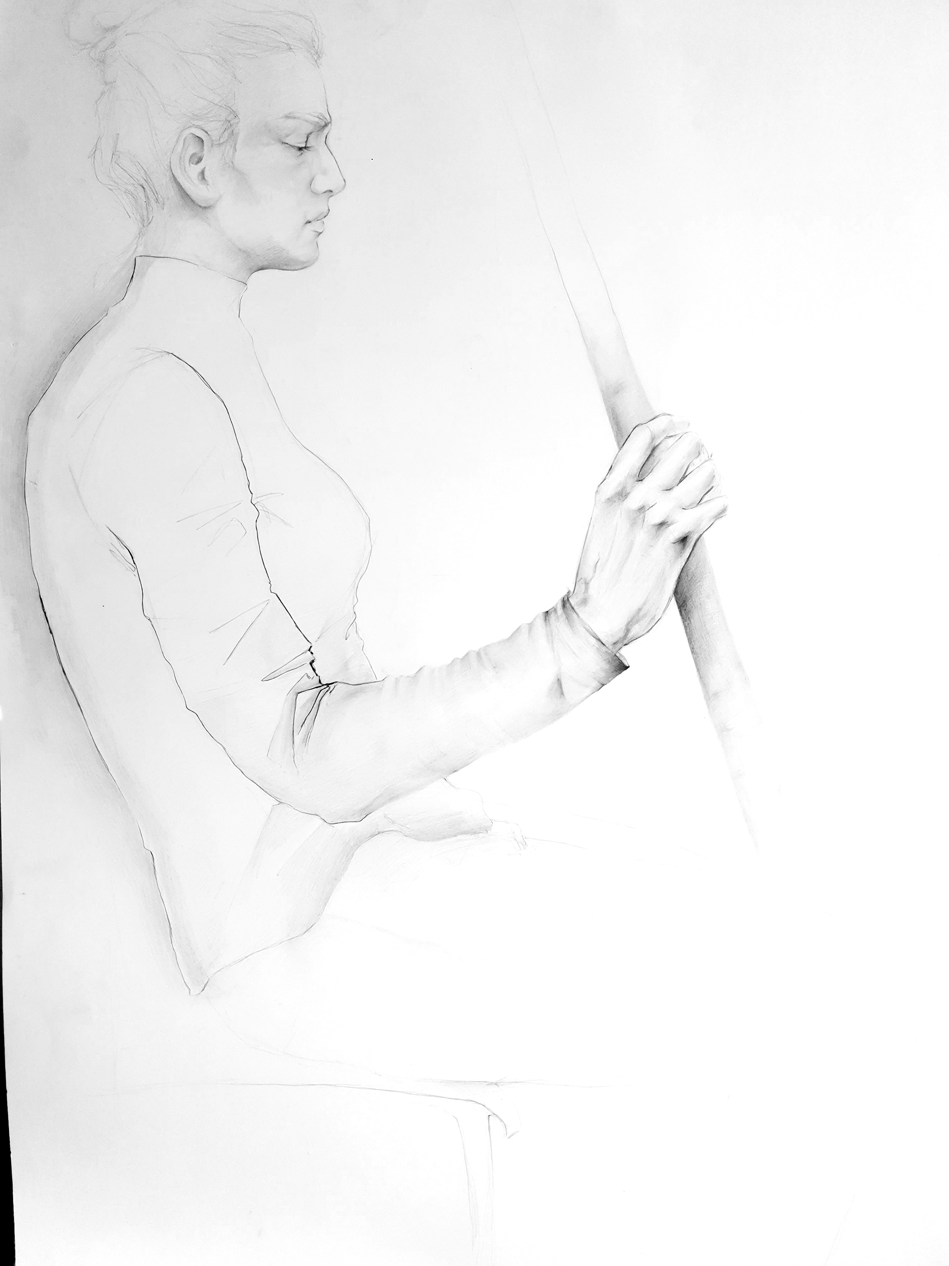 Zdjęcie przedstawia studium modelki siedzącej na krześle, trzymającej kij w prawej dłoni. Rysunek wykonany ołówkiem na formacie papieru 70x100 cm.
