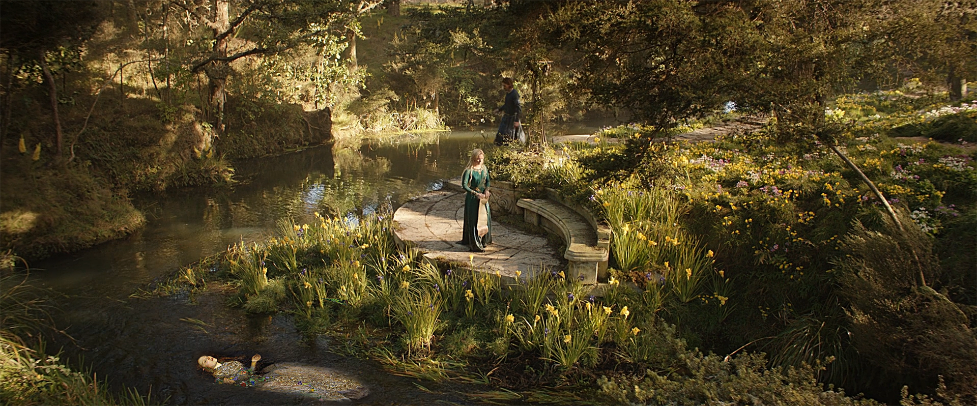 Grafika cyfrowa reprodukująca wybrany kadr z serialu ,,Pierścienie władzy” (z motywem ogrodu, rzeki i stojącej w centrum Galadrieli) z wkomponowaną postacią Ofelii z XIX-wiecznego, znanego obrazu Johna Everetta Millaisa. 