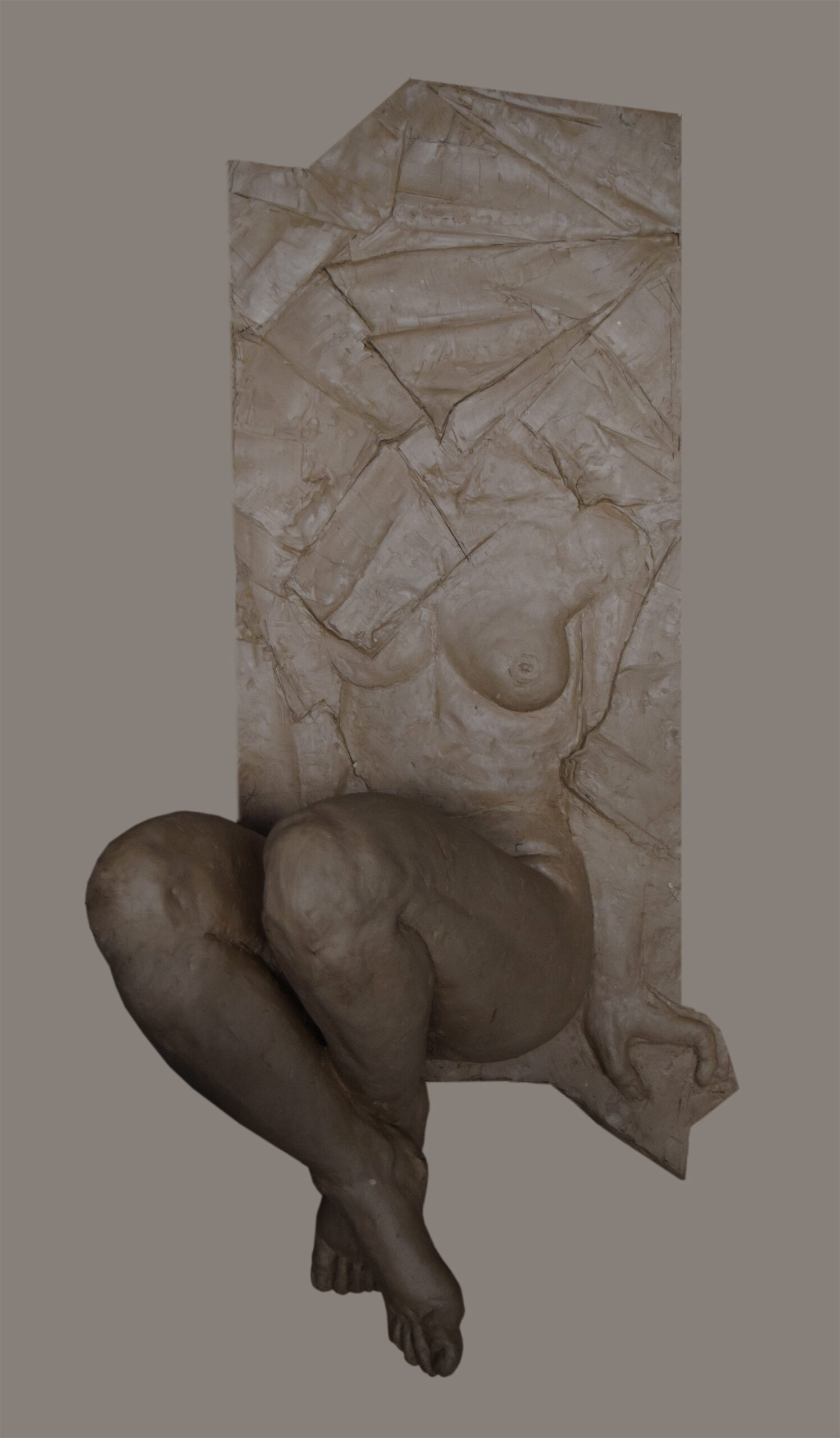 Realistyczna rzeźba wykonana w glinie przedstawiająca nagą postać kobiecą ze skrzyżowanymi nogami. Forma składa się z części płaskorzeźby (górnej) i trójwymiarowej (dolnej).  W części górnej głowa i lewa pierś są zasłonięte formami imitującymi zgięty papier, prawa pierś i brzuch są odsłonięte. Od bioder w dół forma przechodzi w trójwymiarową rzeźbę,