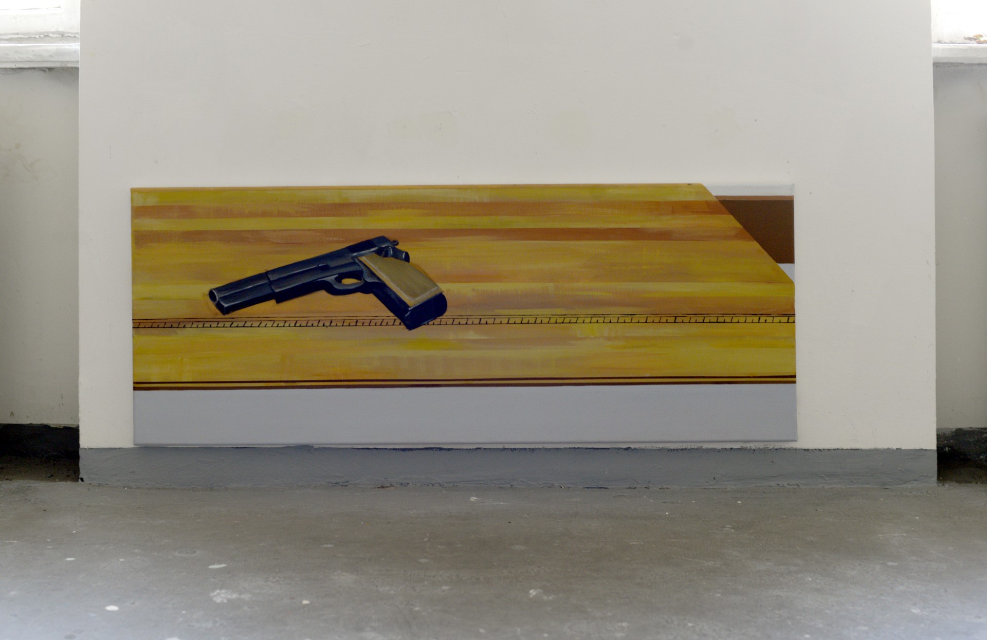 Obraz przedstawia pistolet leżący na drewnianym stole.
