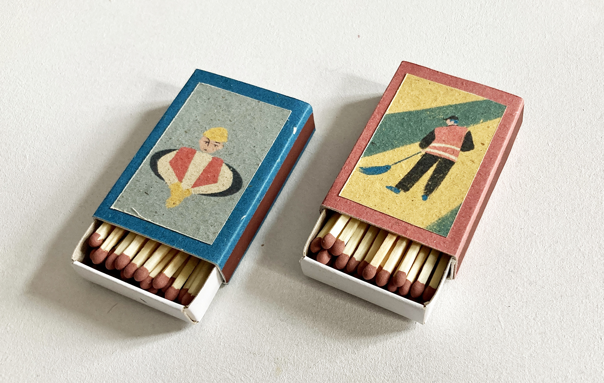 Kompozycja składa się z dwóch otwartych pudełek z zapałkami. Na każdym z pudełek autorska ilustracja. Kolorystyka: przygaszony błękit, żółć, zieleń, czerwień. Ilustracje przedstawiają osoby wykonujące mało prestiżowe zawody np. śmieciarz.