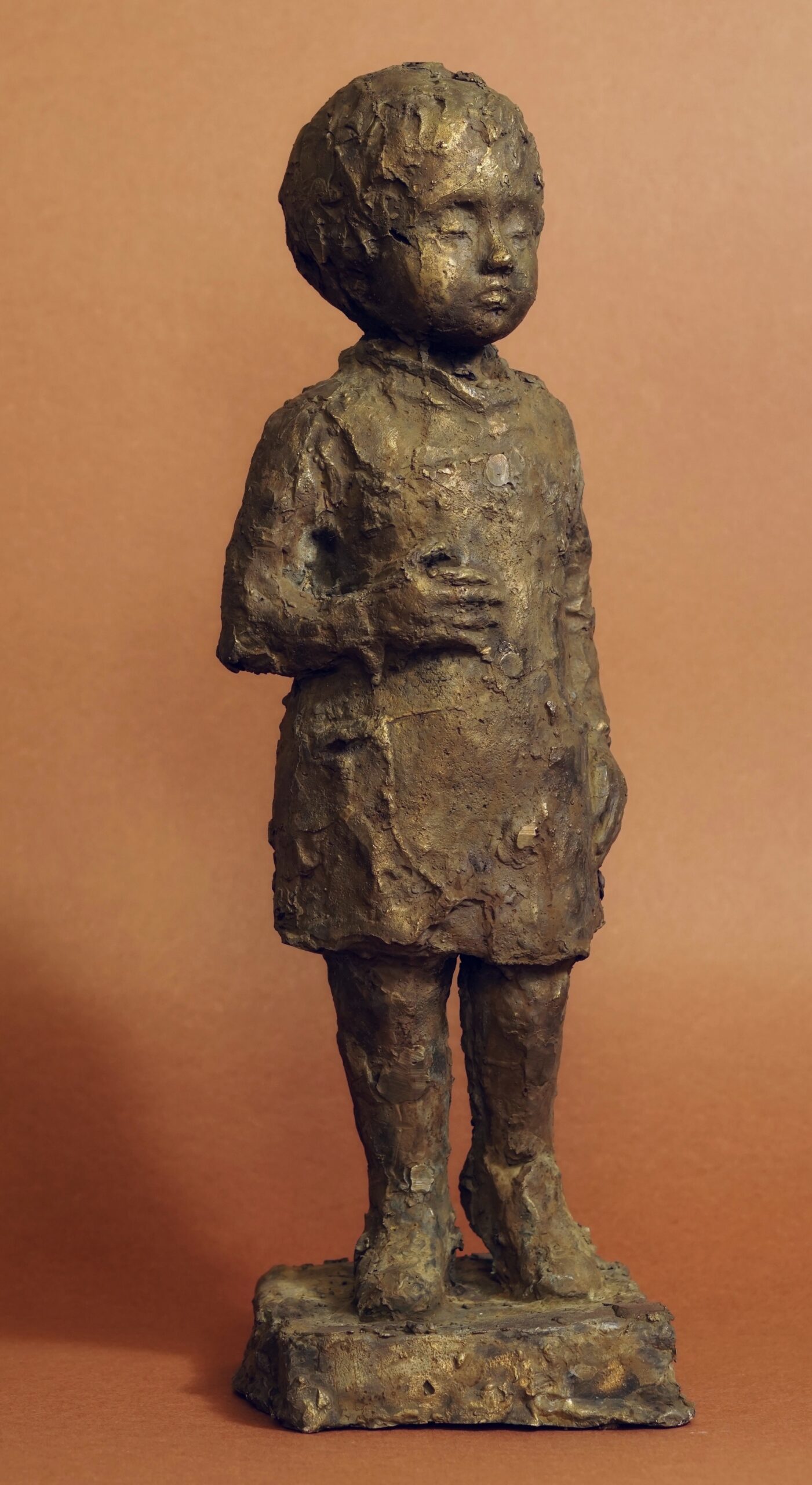 Daria Wasiak- zdjęcie przedstawia rzeźbę małej dziewczynki wykonanej z mosiądzu w brązowej patynie.