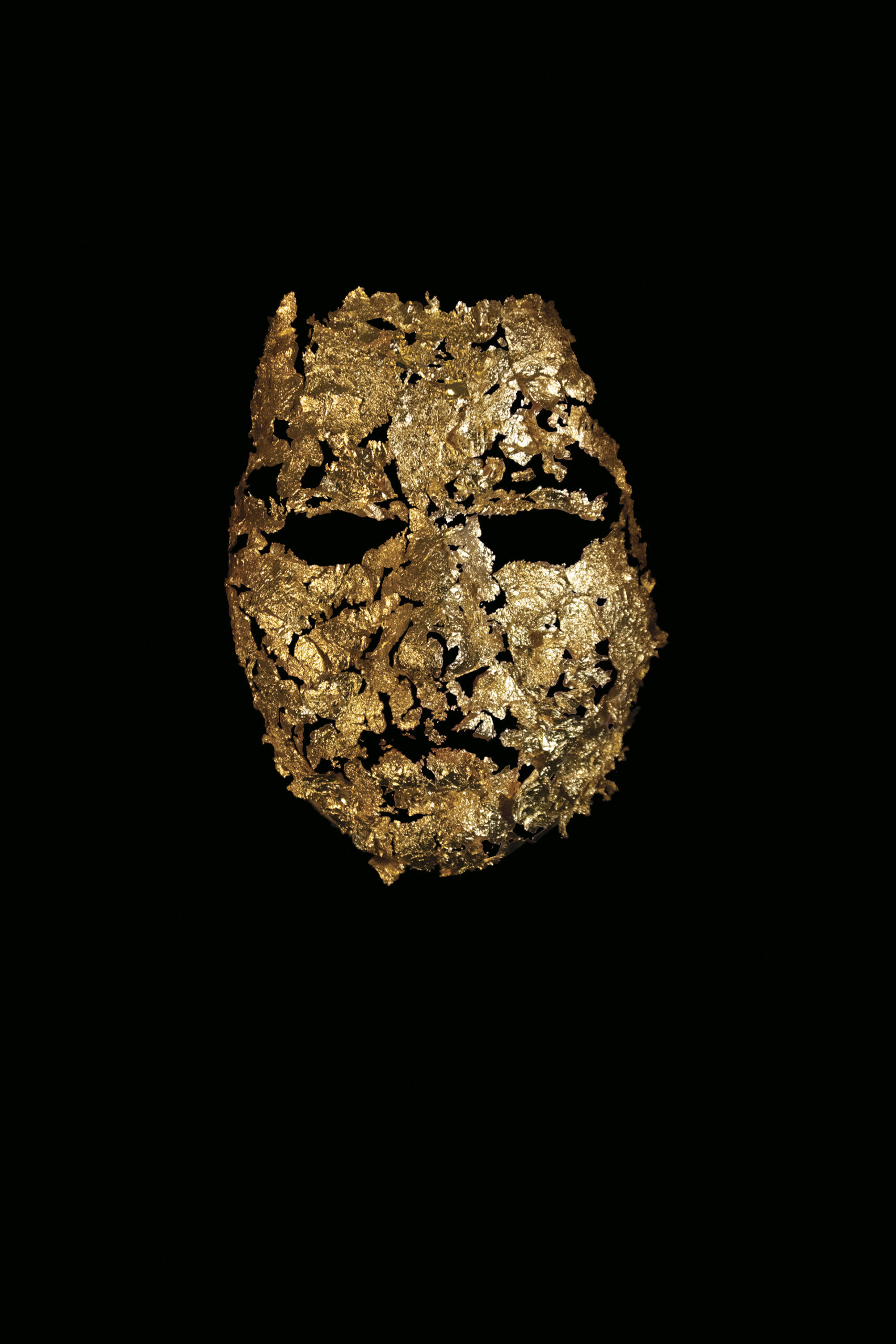 Dyptyk składający się z dwóch fotografii maski ułożonej ze złotych płatków. W pierwszym zdjęciu maska funkcjonuje na czarnym tle, w drugim – na twarzy autorki.