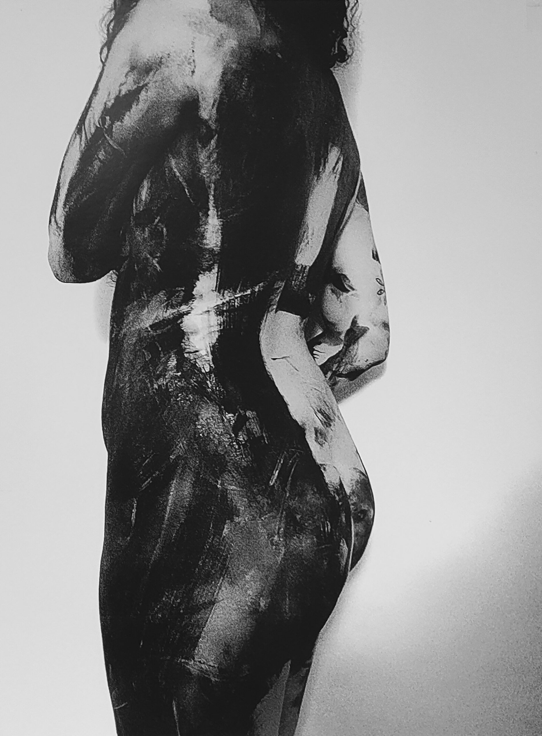 Obraz przedstawia tułów odwróconej tyłem, nagiej kobiety. Jej ciało pomalowane jest farbą. Obraz jest czarno biały.