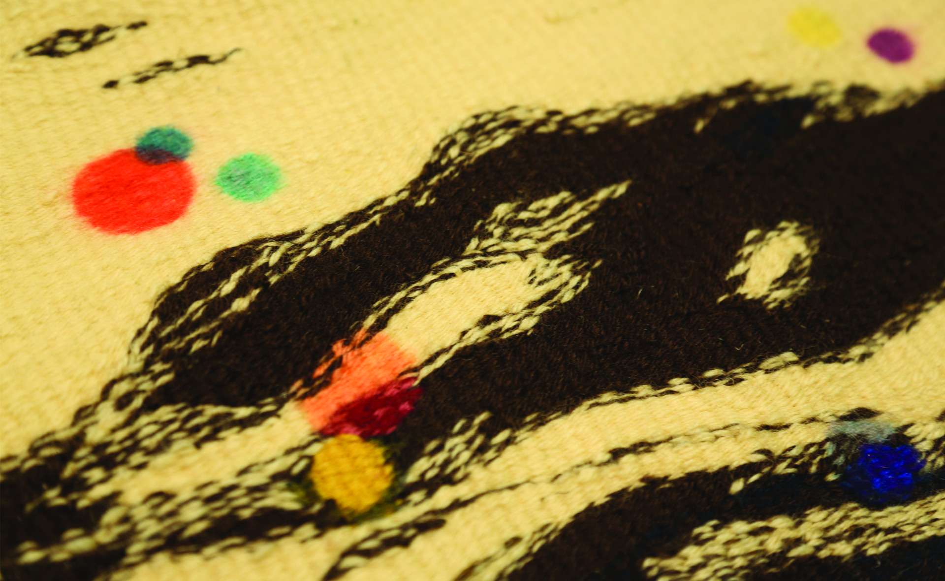 Zdjęcie przedstawia tkaninę w abstrakcyjne formy organiczne, lekko rozwibrowaną ku krawędziom. W niektórych miejscach znajdują się kolorowe owalne formy