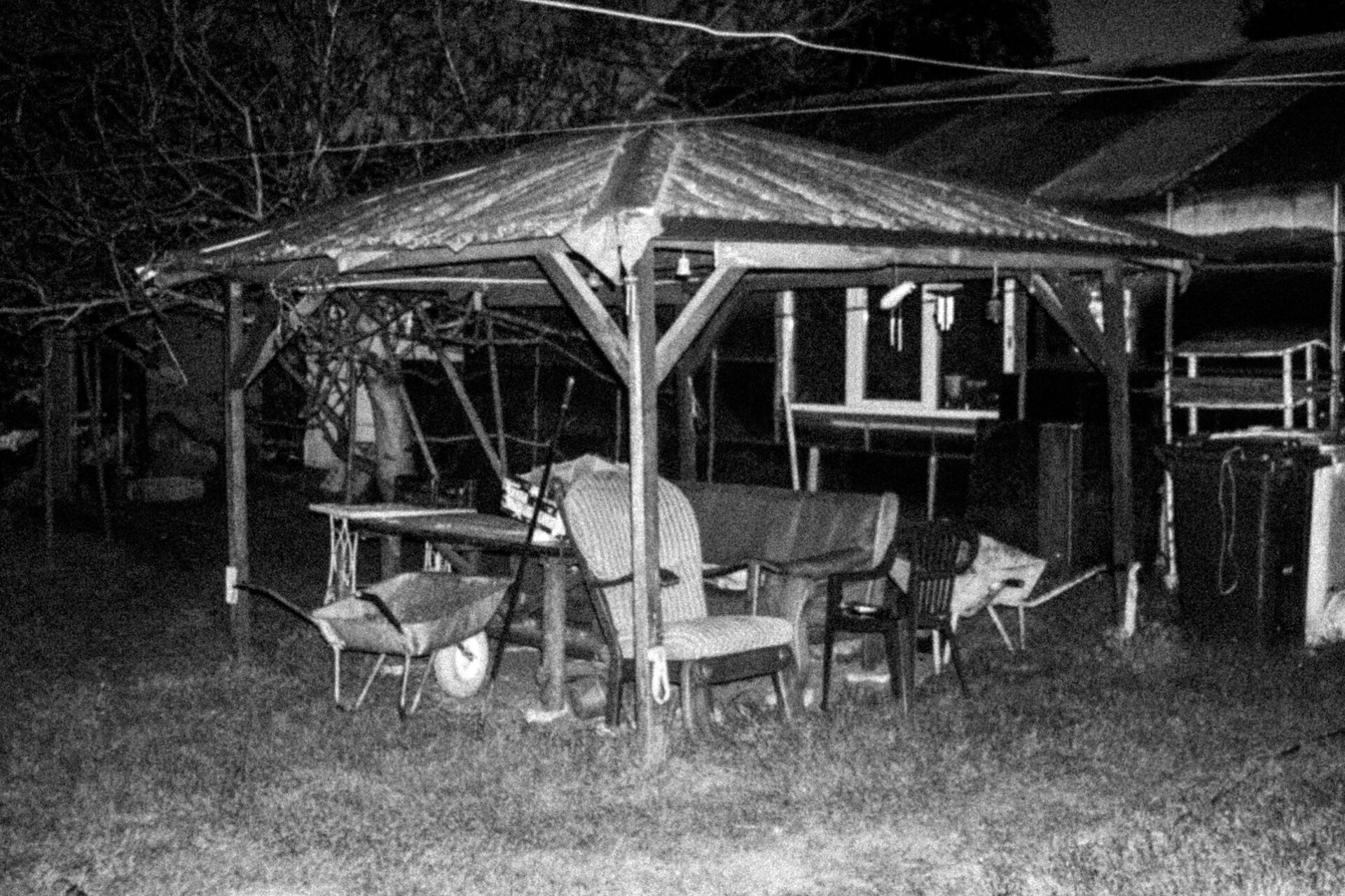 Czarno białe fotografie przedstawiają fragmenty domu, furtki, podwórka, jakiegoś budynku w oddali, altany, meble. Są fotografowane za pomocą lampy błyskowej co podbija ich mroczny charakter. 